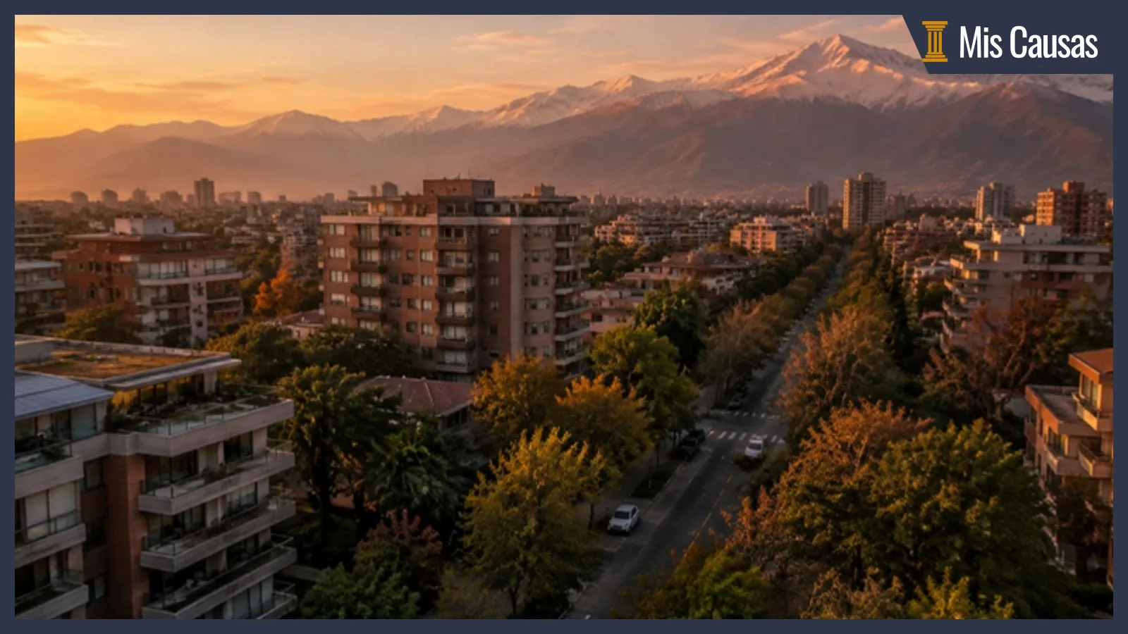 Vista aérea de un barrio residencial de Santiago con edificios de mediana altura, calles arboladas y la cordillera de los Andes al atardecer